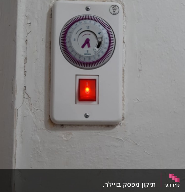 טיימר חשמלי עם מתג מואר על קיר לבן